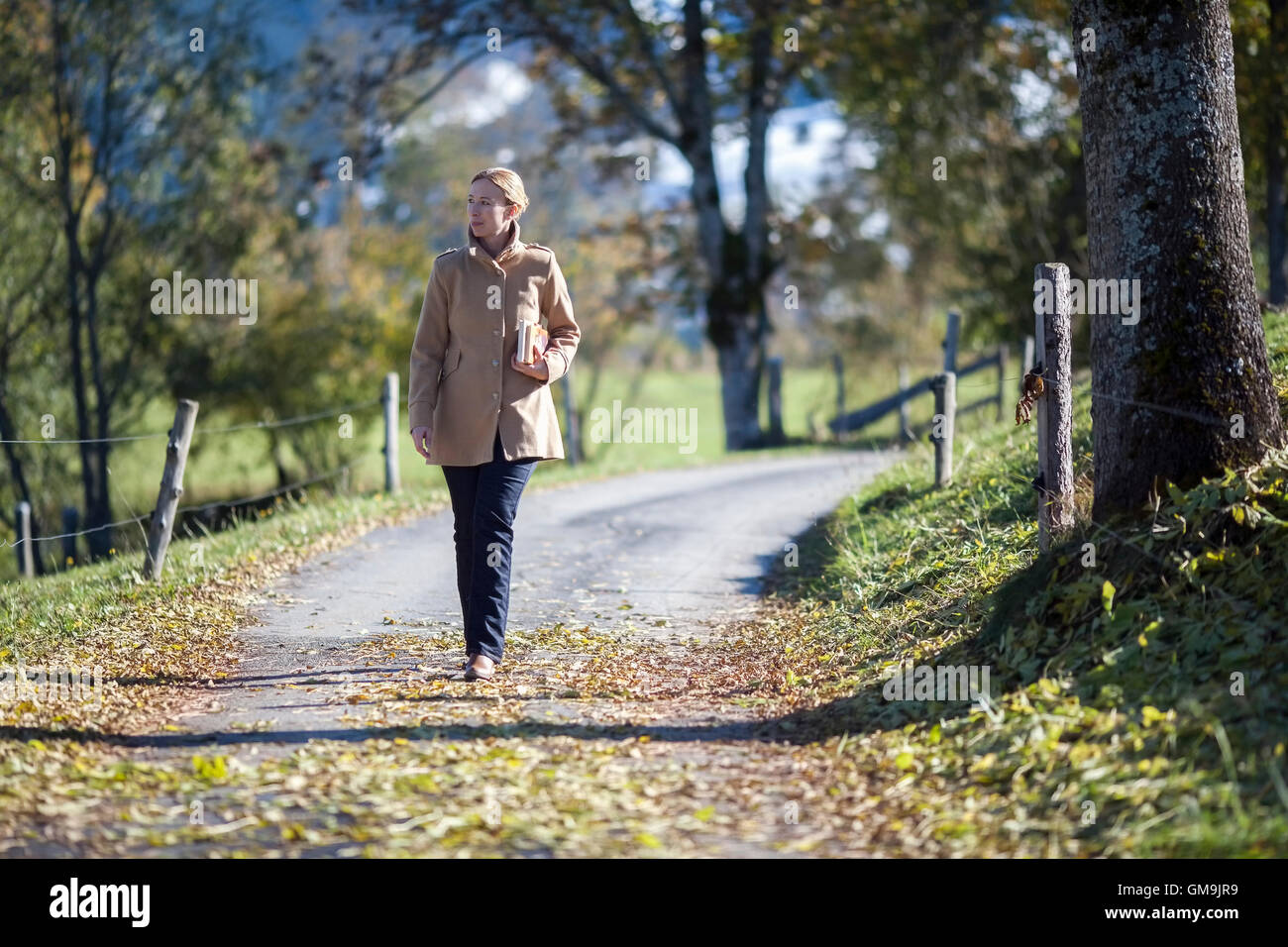 Austria, Salzburger Land, Maria Alm, Mature woman walking on autumn alley Stock Photo