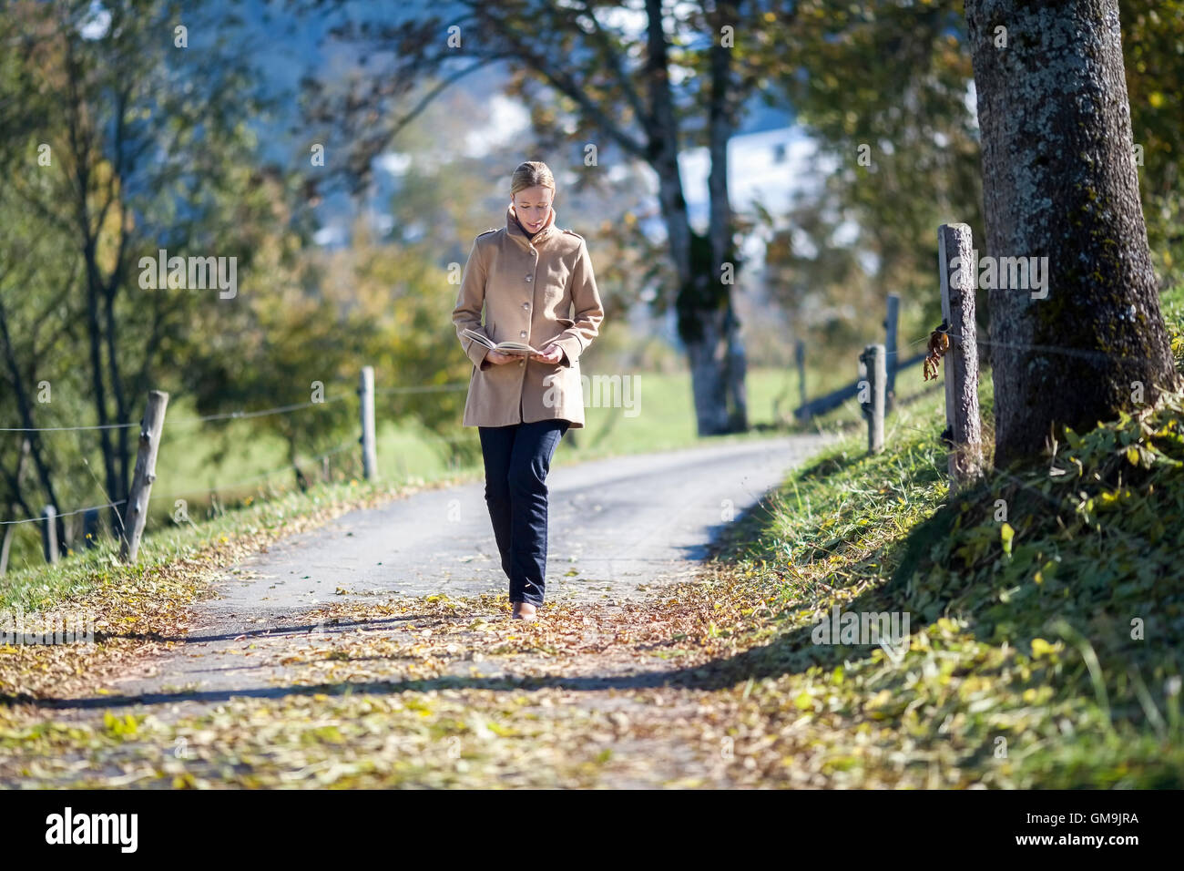Austria, Salzburger Land, Maria Alm, Mature woman walking on autumn alley Stock Photo