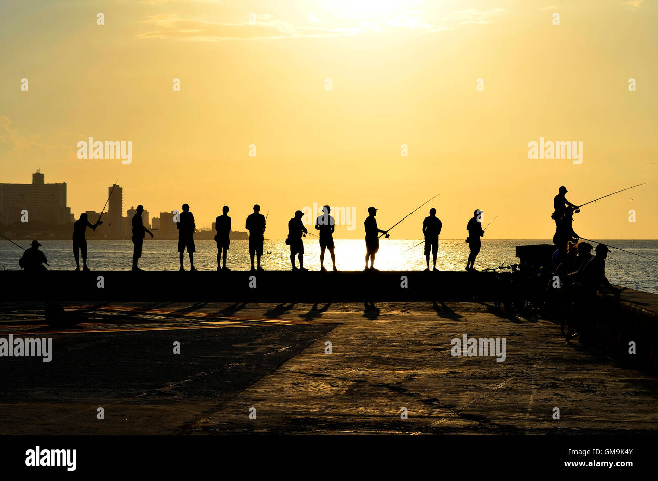 Every day, before sunset, dozens of fishermen meet in the Malecon (Havana's harbour). Stock Photo
