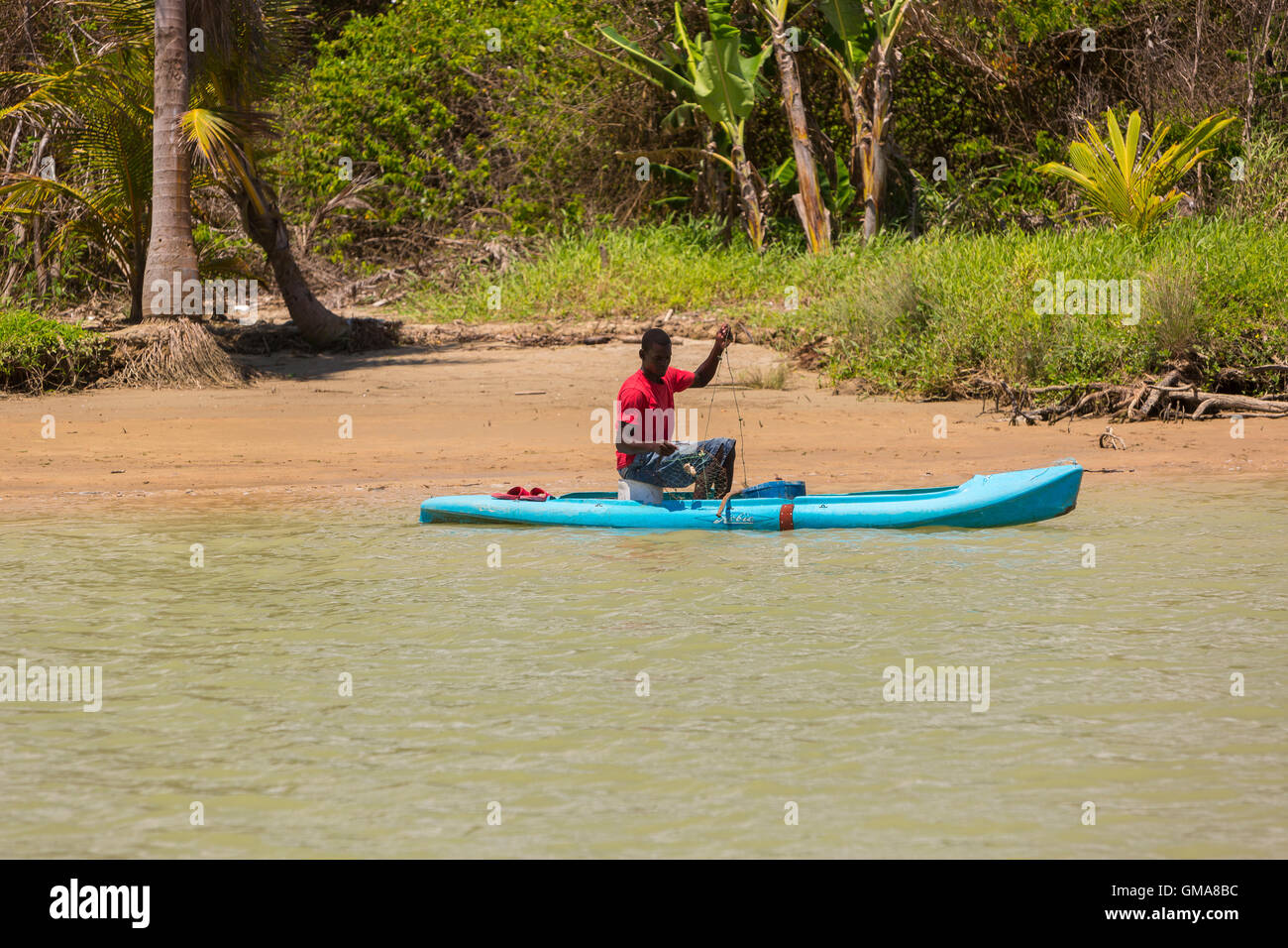 CABARETE, DOMINICAN REPUBLIC - Man in small boat fishing for blue crabs, at mouth of Yasica River. Stock Photo