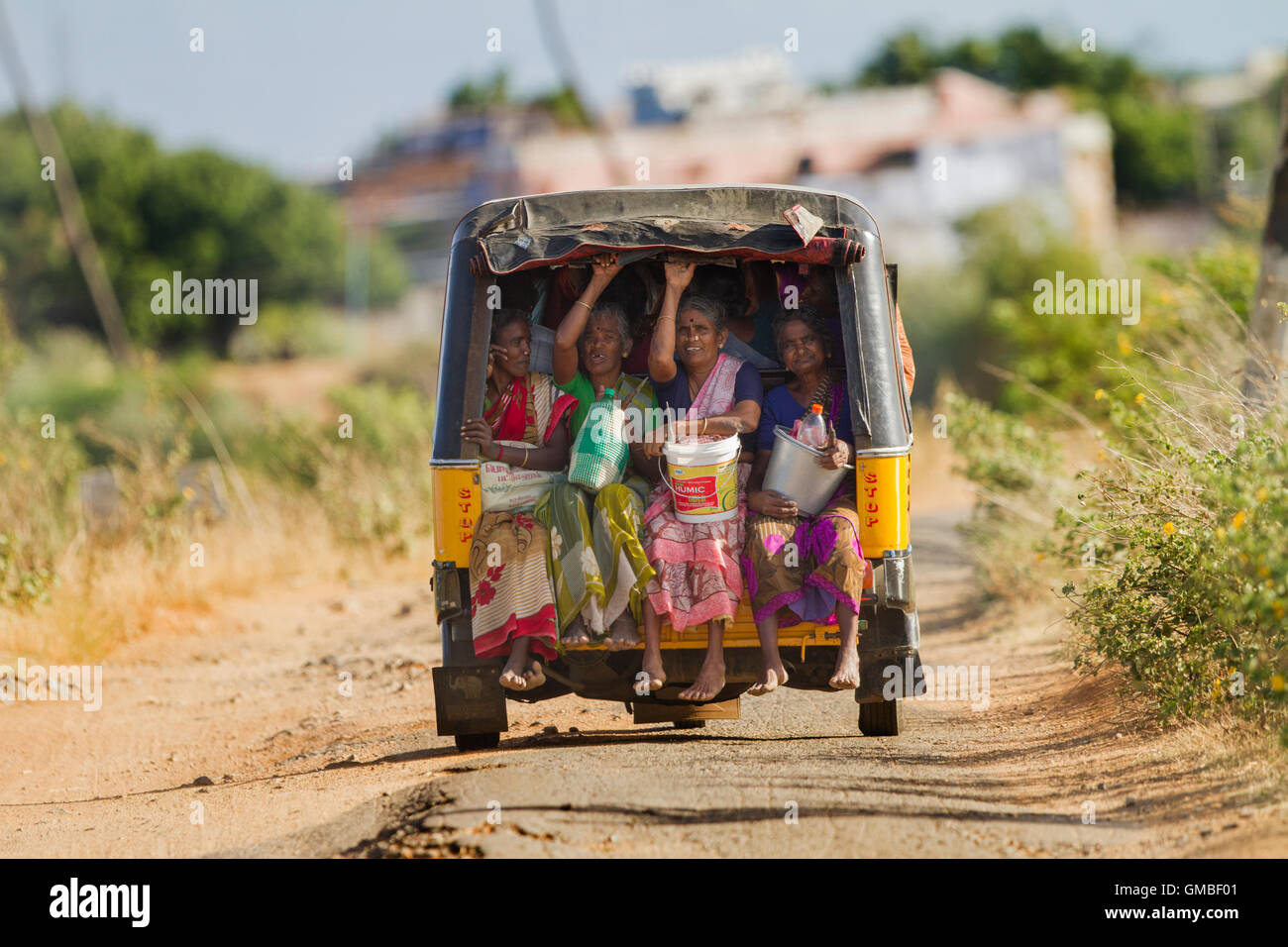 Women farming workers are traveling in an autorickshaw, a village view ...