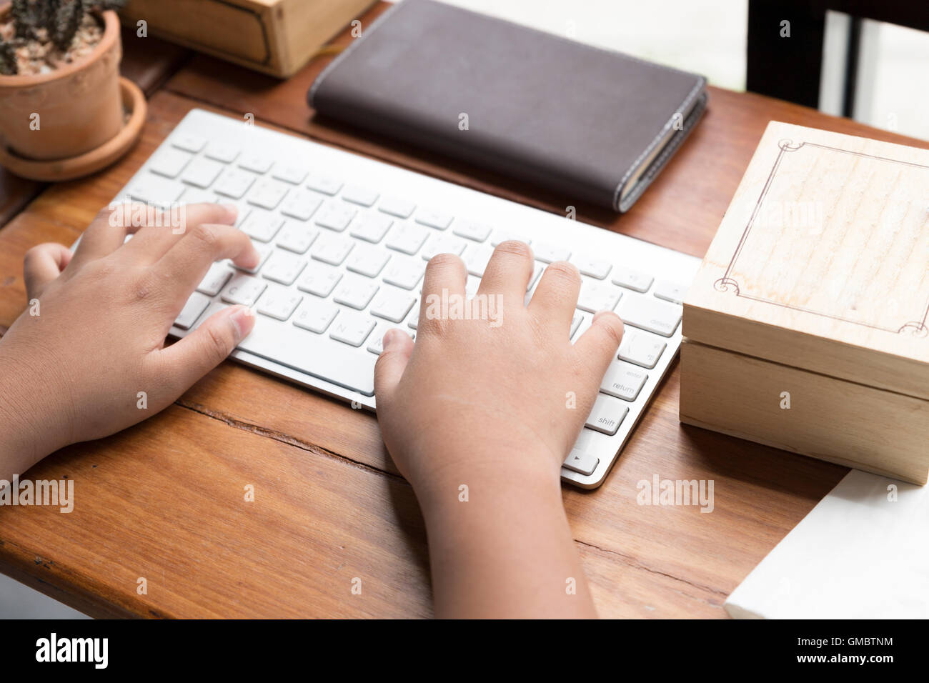 kid's hand on computer keyboard with notebook and wooden box Stock ...