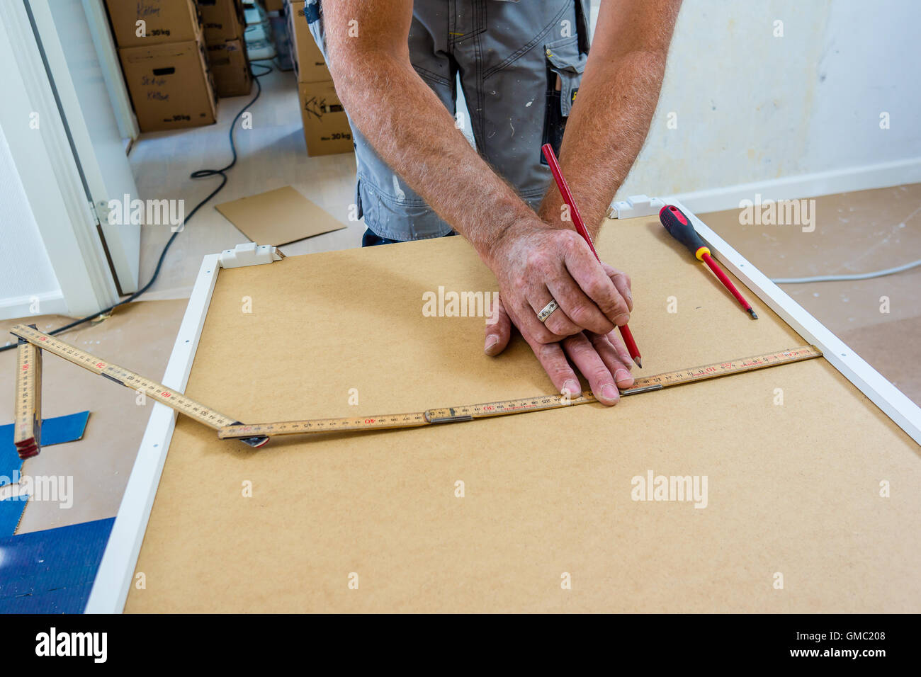 carpenter mounting IKEA kitchen Stock Photo
