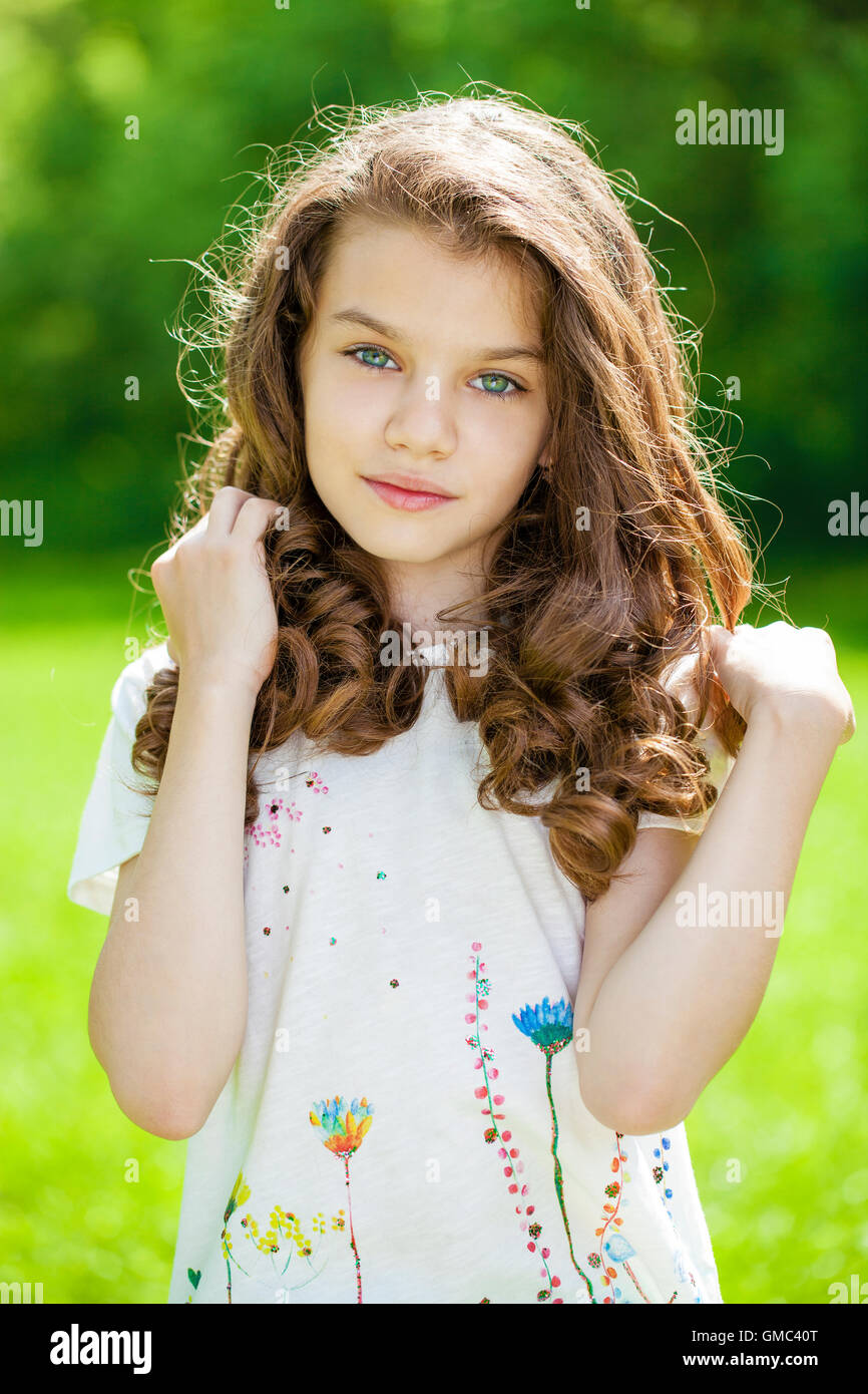 Portrait of a beautiful young little girl on the background of summer ...