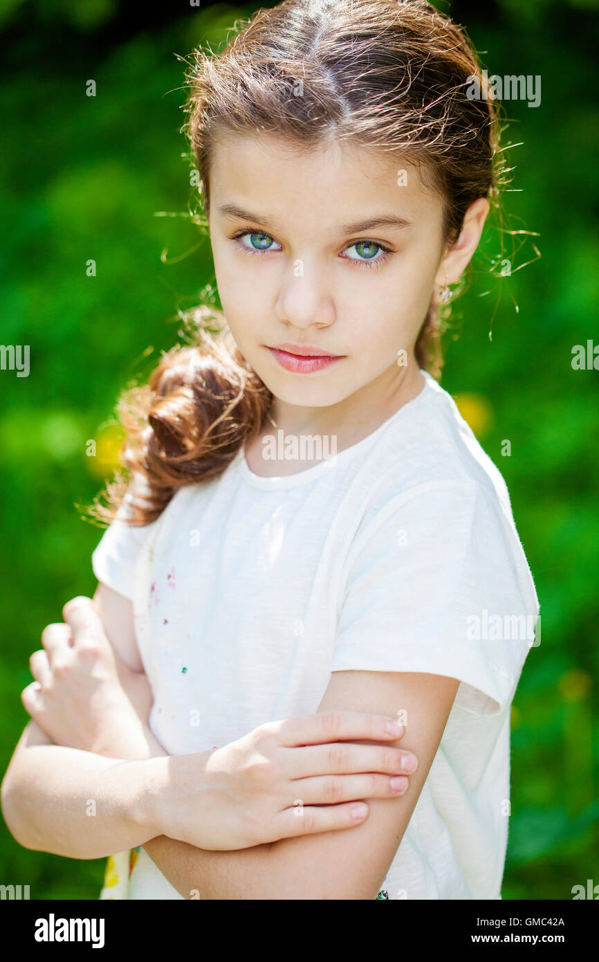 Portrait of a beautiful young little girl on the background of summer ...