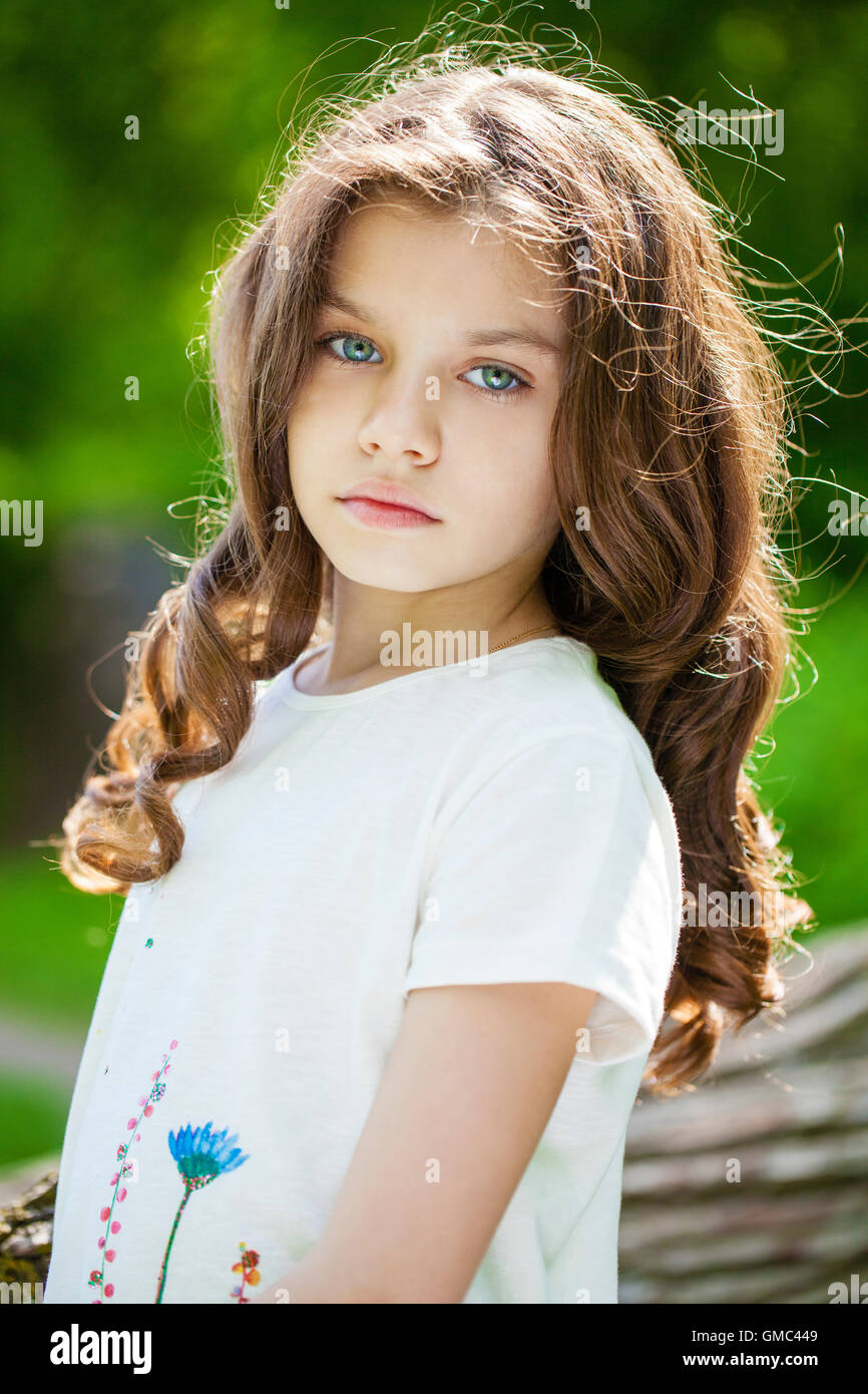 Portrait of a beautiful young little girl on the background of summer ...