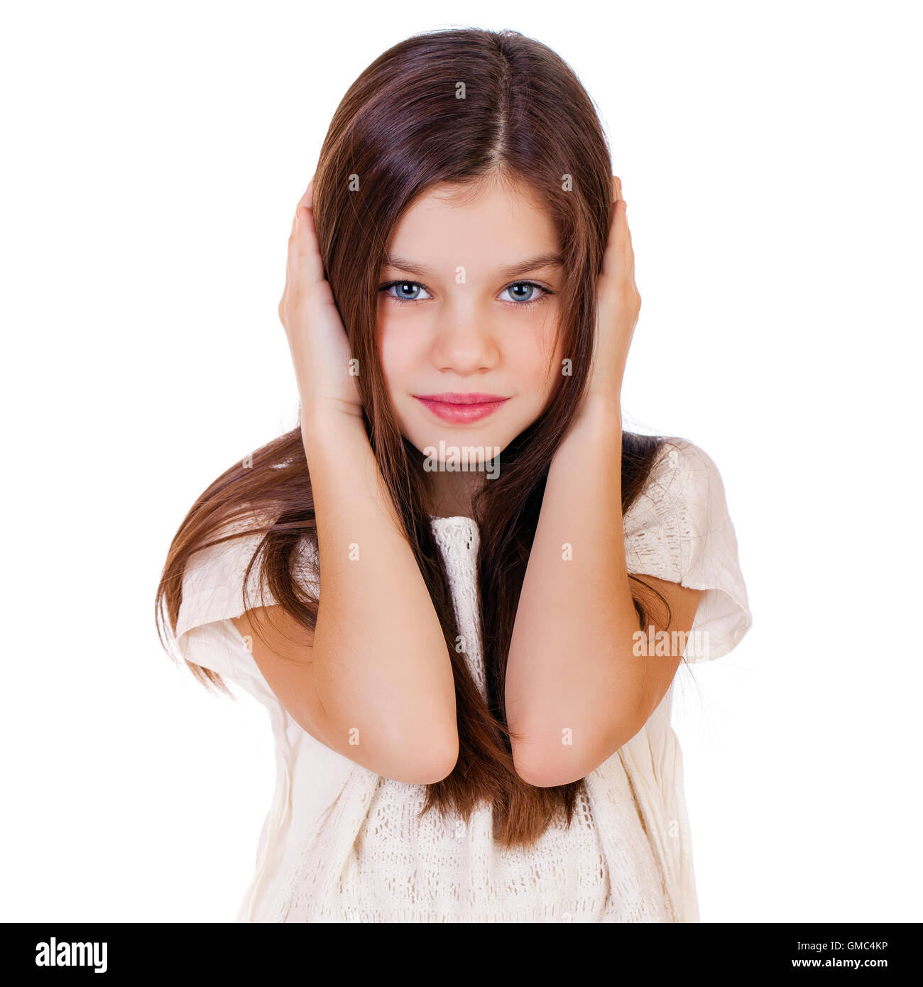 Portrait of a charming little girl covering ears with hands, isolated