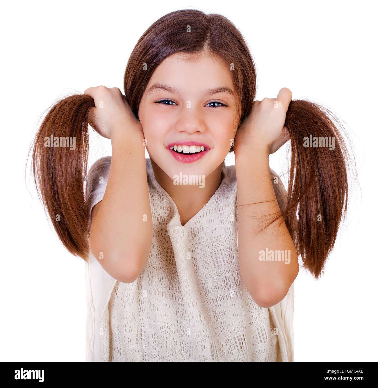 Portrait of a charming little girl smiling at camera, isolated on white ...