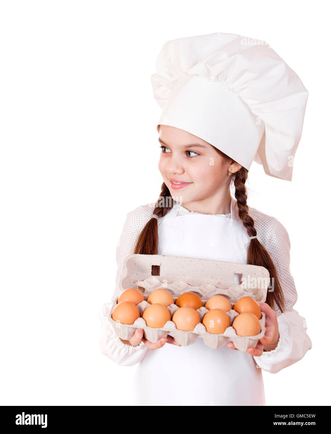 Portrait of a little girl in a white apron holding box of raw eggs, isolated on white background Stock Photo