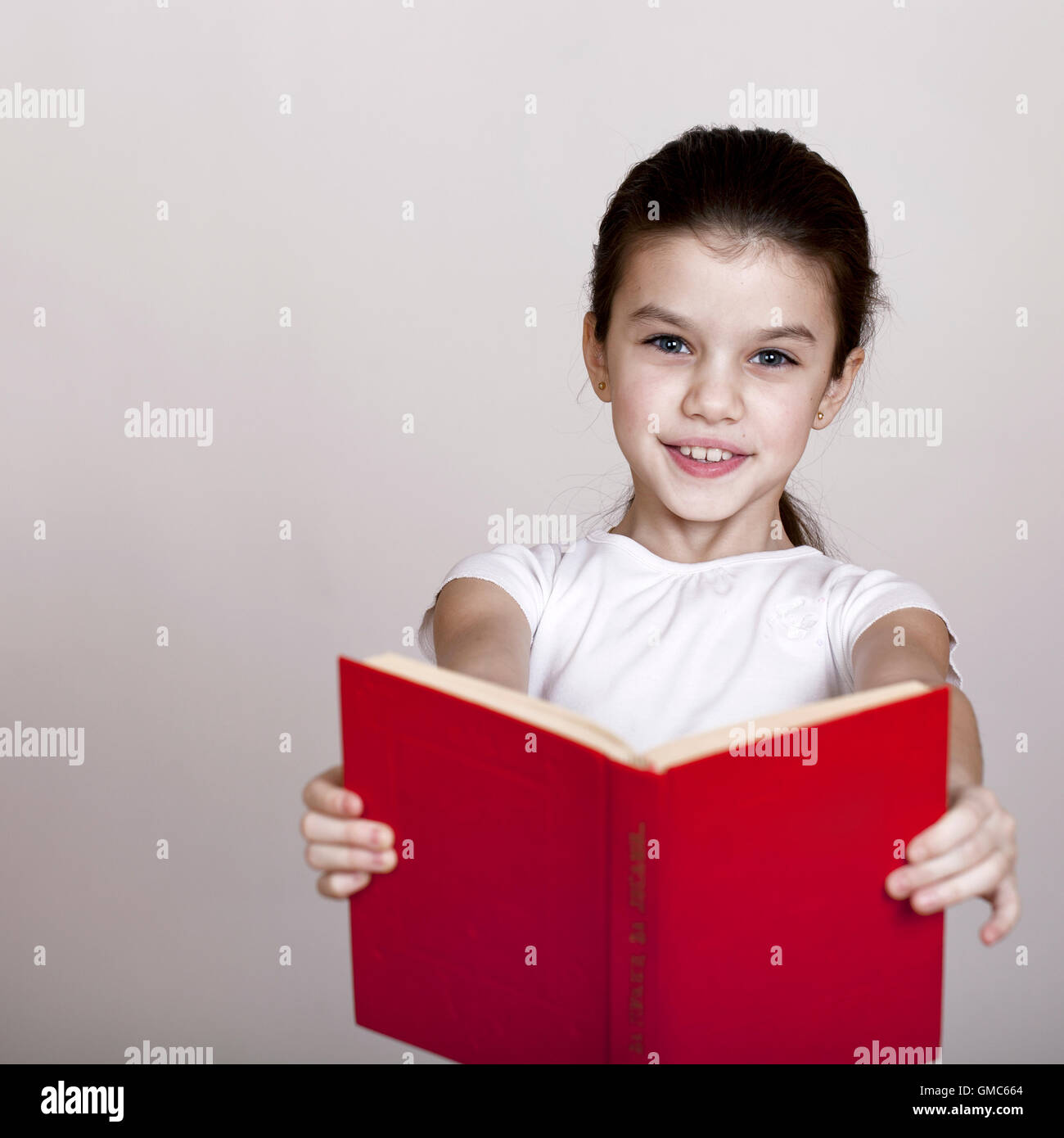 Little girl holding red book, studio on white background Stock Photo ...