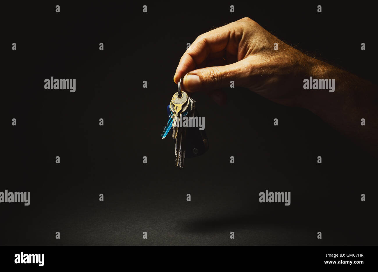 Conceptual composition about having a solution, good life or similar. Man's hand holding a keys. Stock Photo