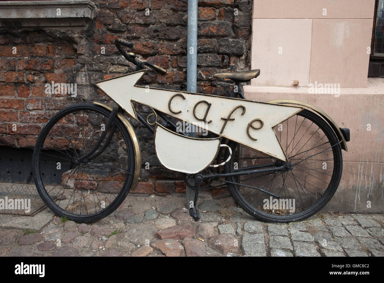 Vintage retro classic city bike, bicycle with an arrow sign pointing to a cafe Stock Photo