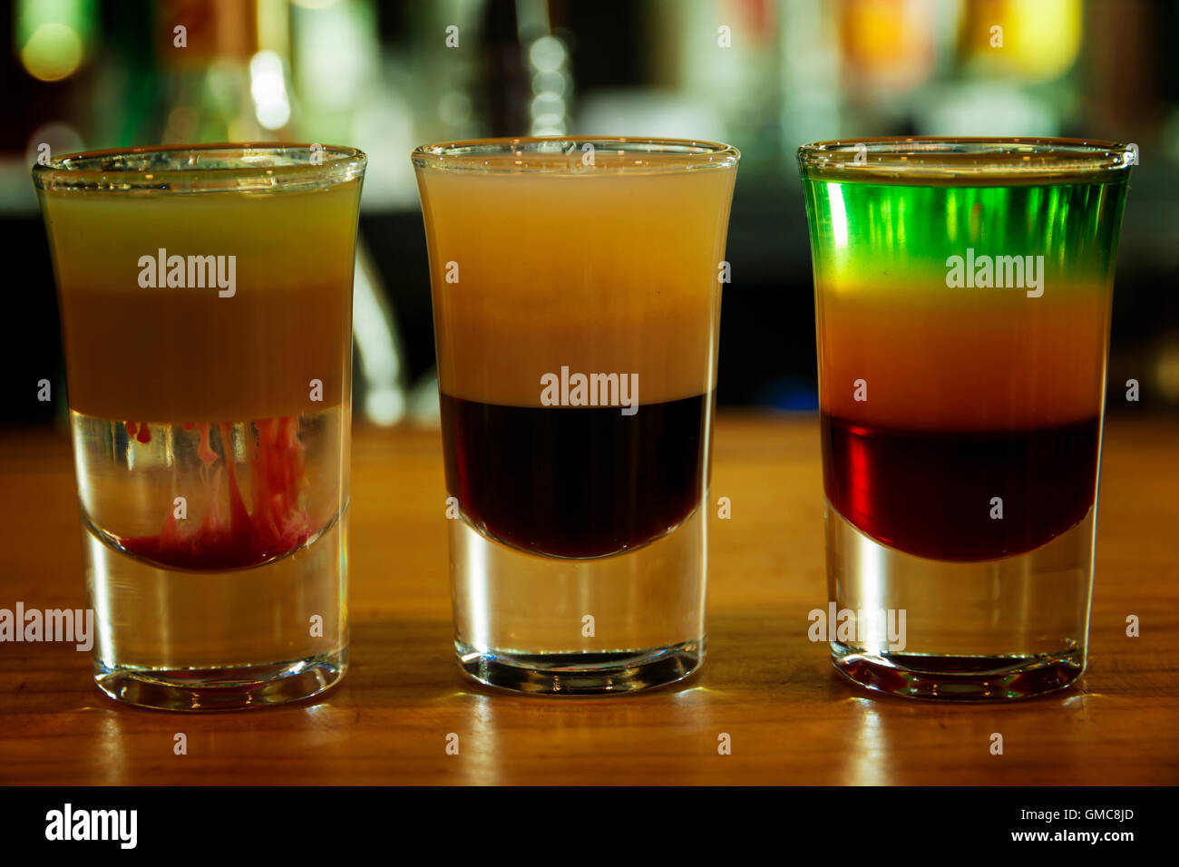 Several different alcohol multi colored shots in bar Stock Photo