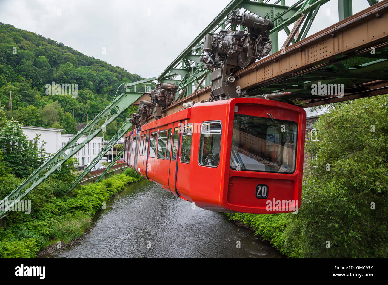 Red wagon of Wuppertal Suspension Railway going above the river Wupper Stock Photo