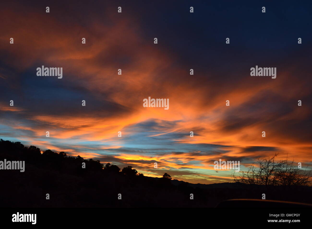 Dreamy skies with blues, oranges, purples with mountain range Stock Photo