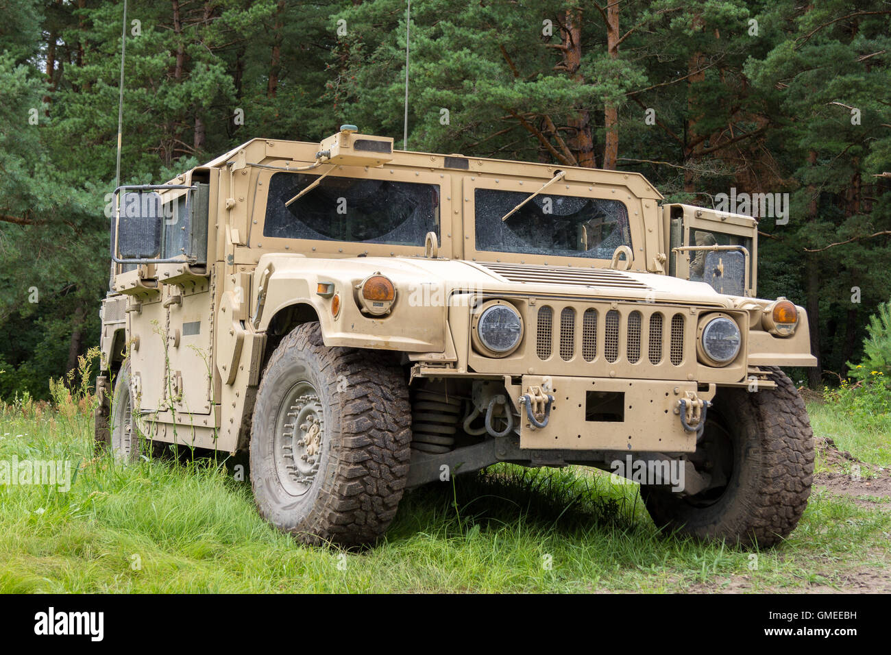 military vehicle stands on green terrain Stock Photo