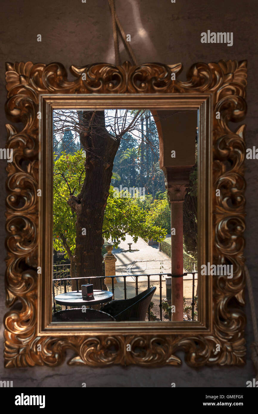 View of the Jardin del Marqués de La Vega-Inclán, reflected in an elaborate wall mirror, Real Alcázar Gardens, Sevilla, Spain Stock Photo