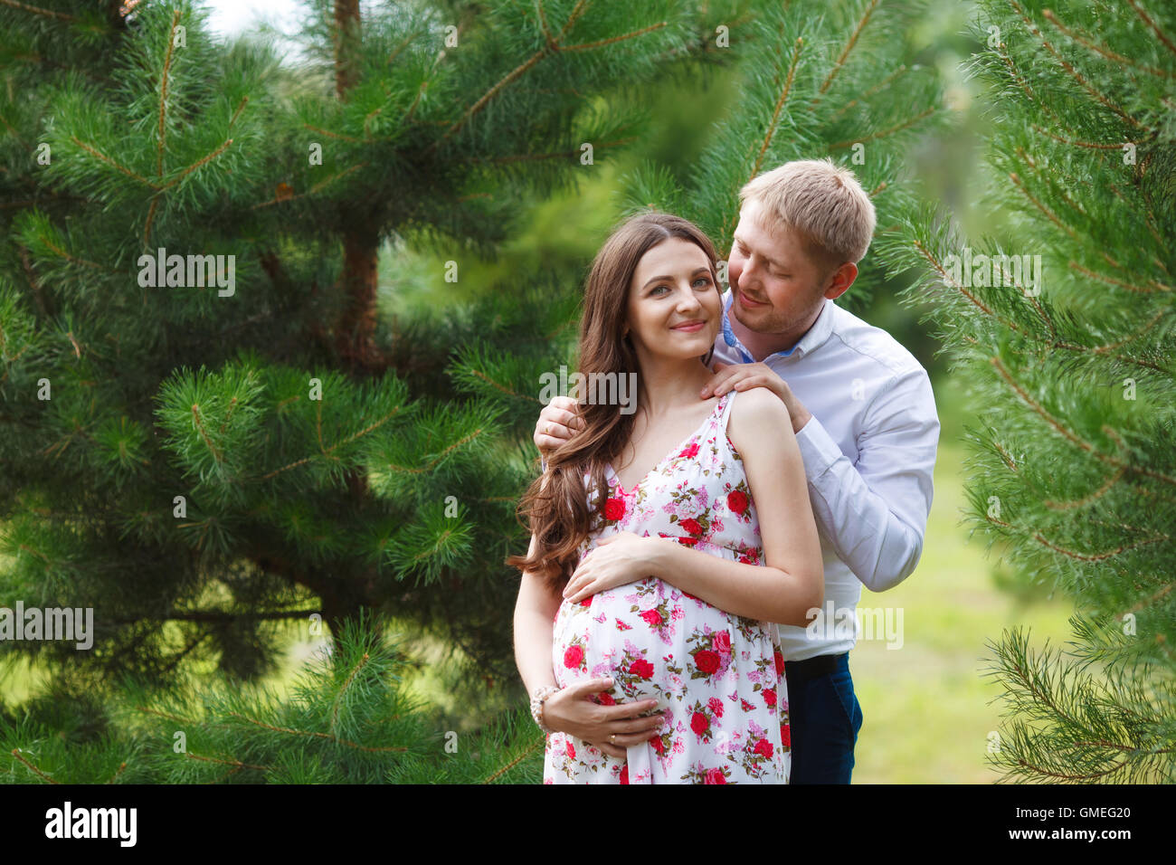 Pregnant woman with husband walking in the park Stock Photo - Alamy