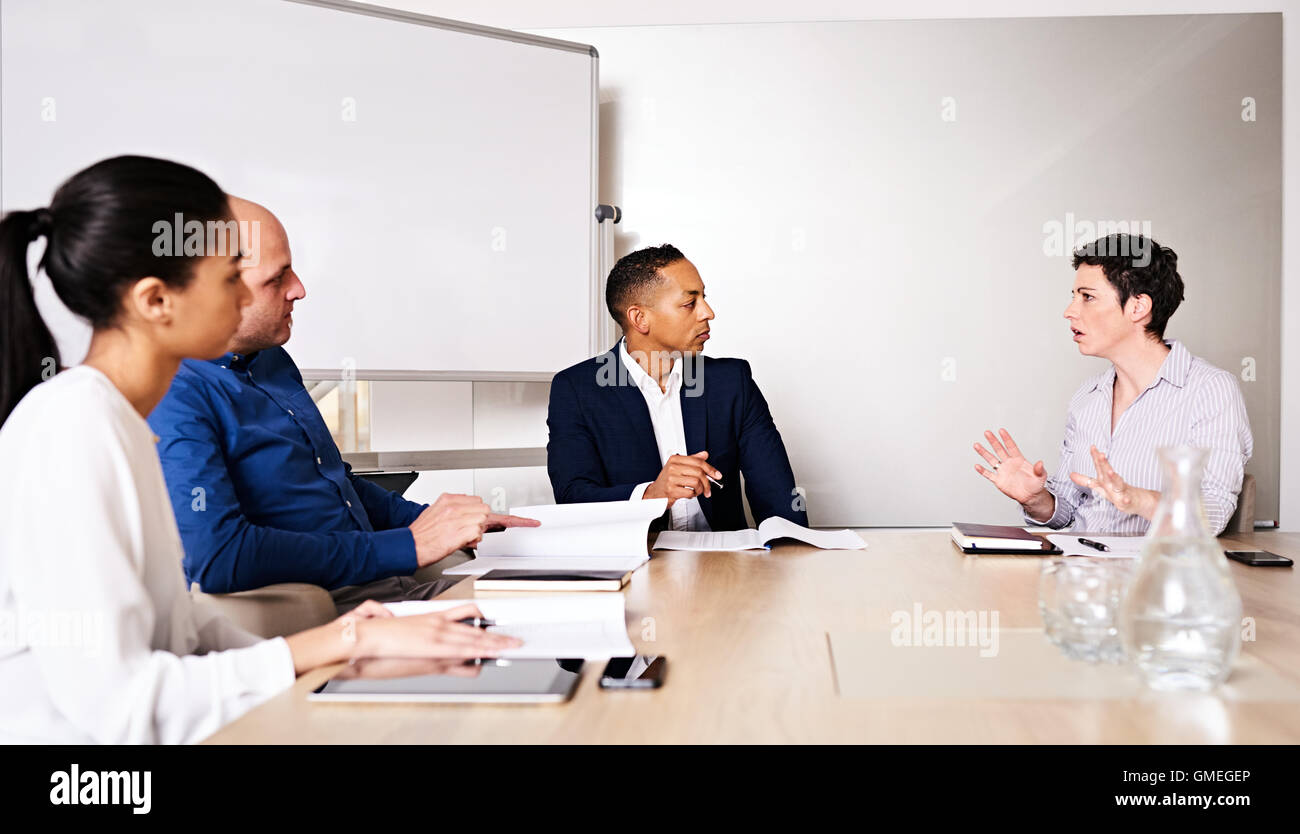 Professional business meeting between 4 educated, racially diverse entrepreneurs Stock Photo