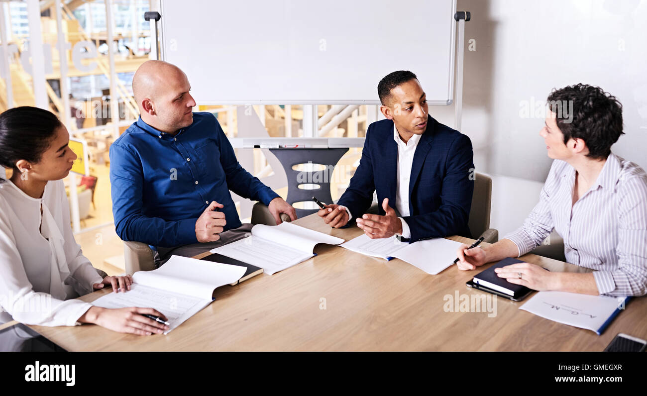Annual general meeting between four educated and diverse individuals Stock Photo