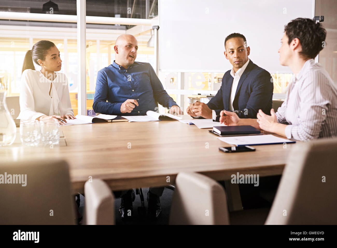 Business meeting between four high power, racially diverse, eclectic individuals Stock Photo