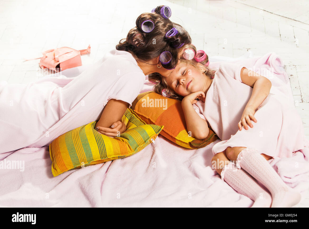 Little girl slipping with her mother in bed on white Stock Photo Alamy