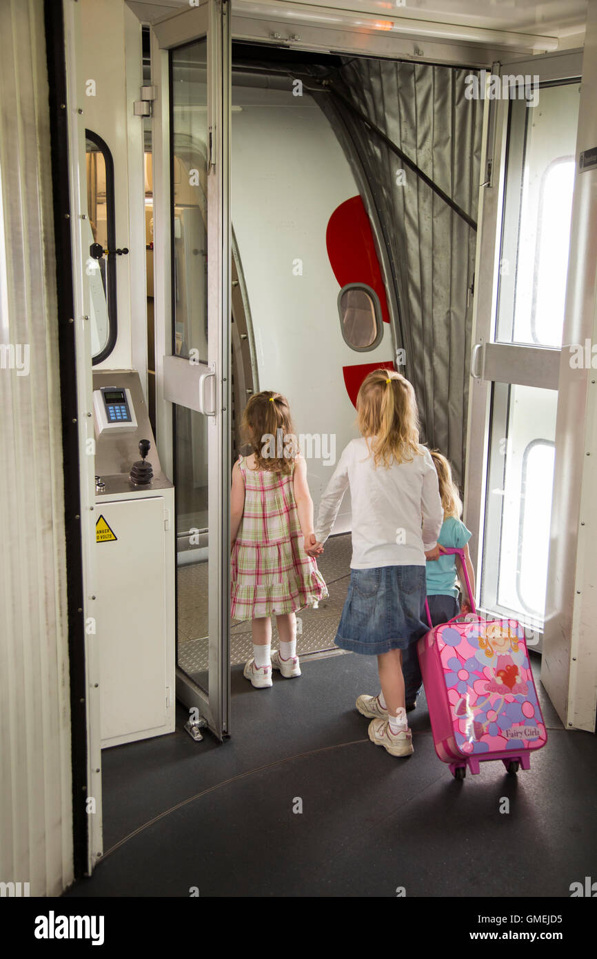 Child kid kids children / passengers board / boarding plane / airplane door. LHR London UK