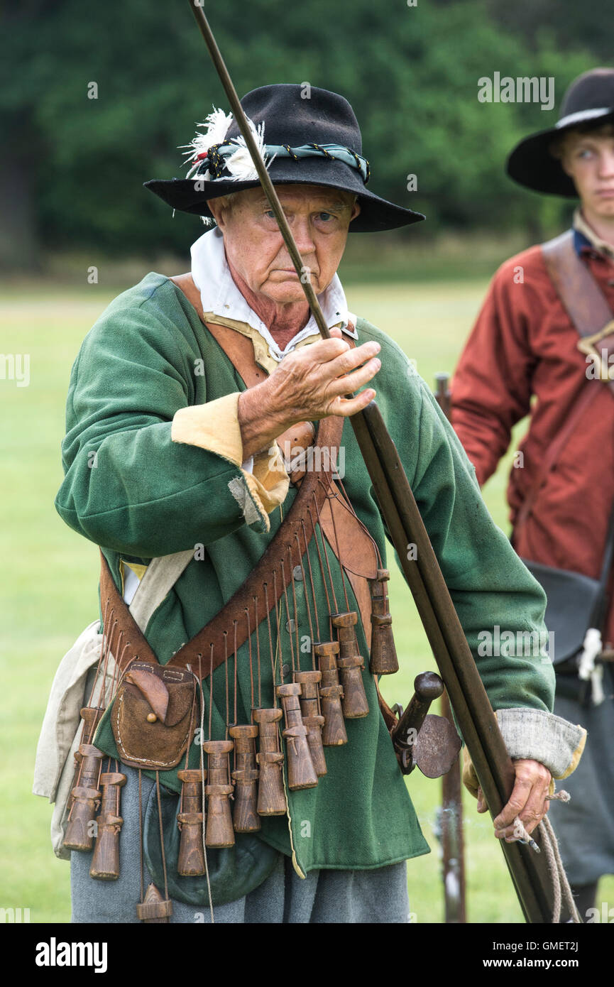 English Civil War Royalist soldier preparing his musket at a reenactment, Spetchley Park, Worcestershire, England Stock Photo