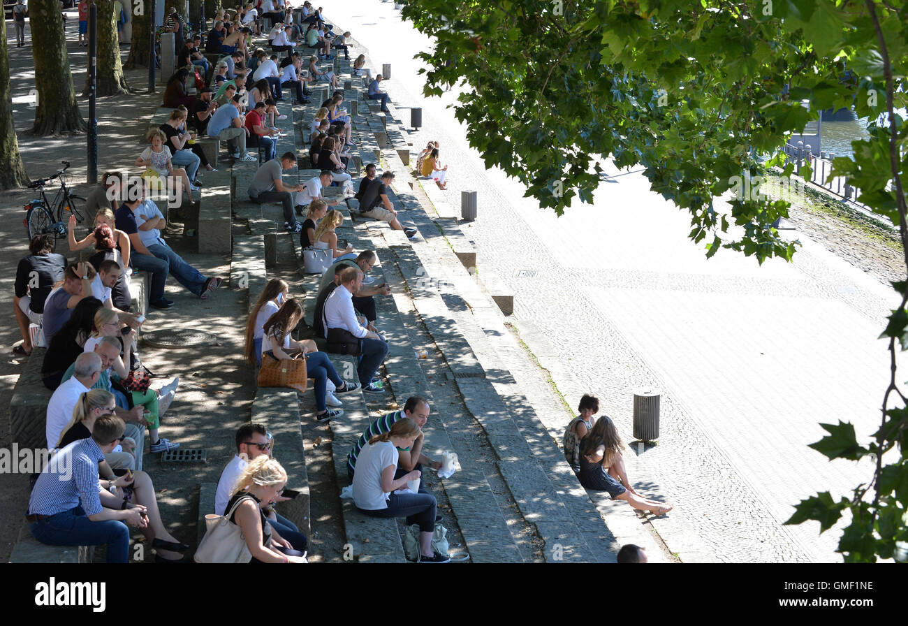 Bremen, Germany. 25th Aug, 2016. Numerous people sit on the banks of the river Weser and enjoy their lunch break in the shade in Bremen, Germany, 25 August 2016. Photo: Carmen Jaspersen/dpa/Alamy Live News Stock Photo