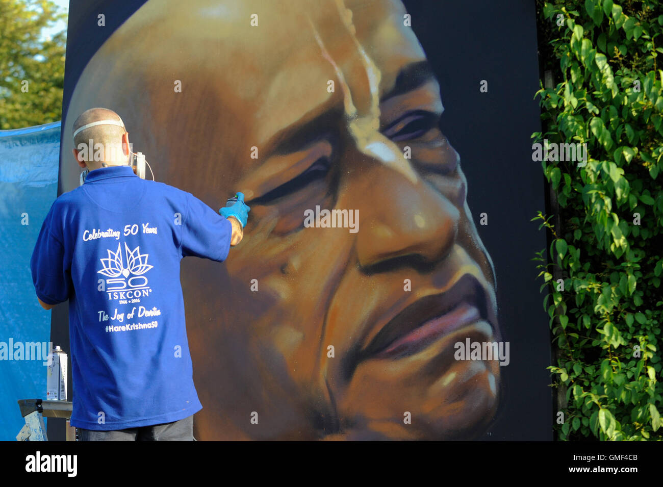 London, UK.  25 August 2016.  A devotee spray paints an image of the founder of ISCON, A.C. Bhaktivedanta, Swami Prabhupada, attend the biggest Janmashtami festival outside of India at the Bhaktivedanta Manor Hare Krishna Temple in Watford, Hertfordshire.  The event celebrates the birth of Lord Krishna. Credit:  Stephen Chung / Alamy Live News Stock Photo
