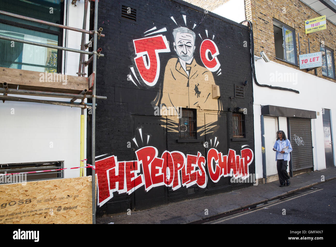London, UK. 26th Aug, 2016. A man walks by a wall painted in support of Labour Party leader Jeremy Corbyn in the London borough of Camden. Corbyn is battling Owen Smith for leadership of the Labour Party which is to be decided on September 24, 2016. Credit:  Joel Ford/Alamy Live News Stock Photo
