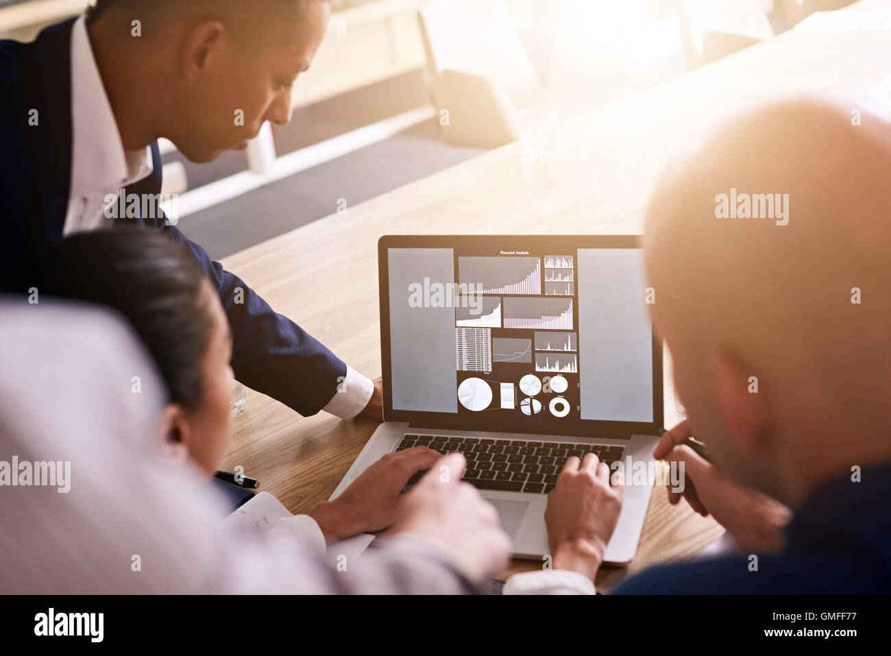 Group of business people looking at graphs on a laptop Stock Photo - Alamy