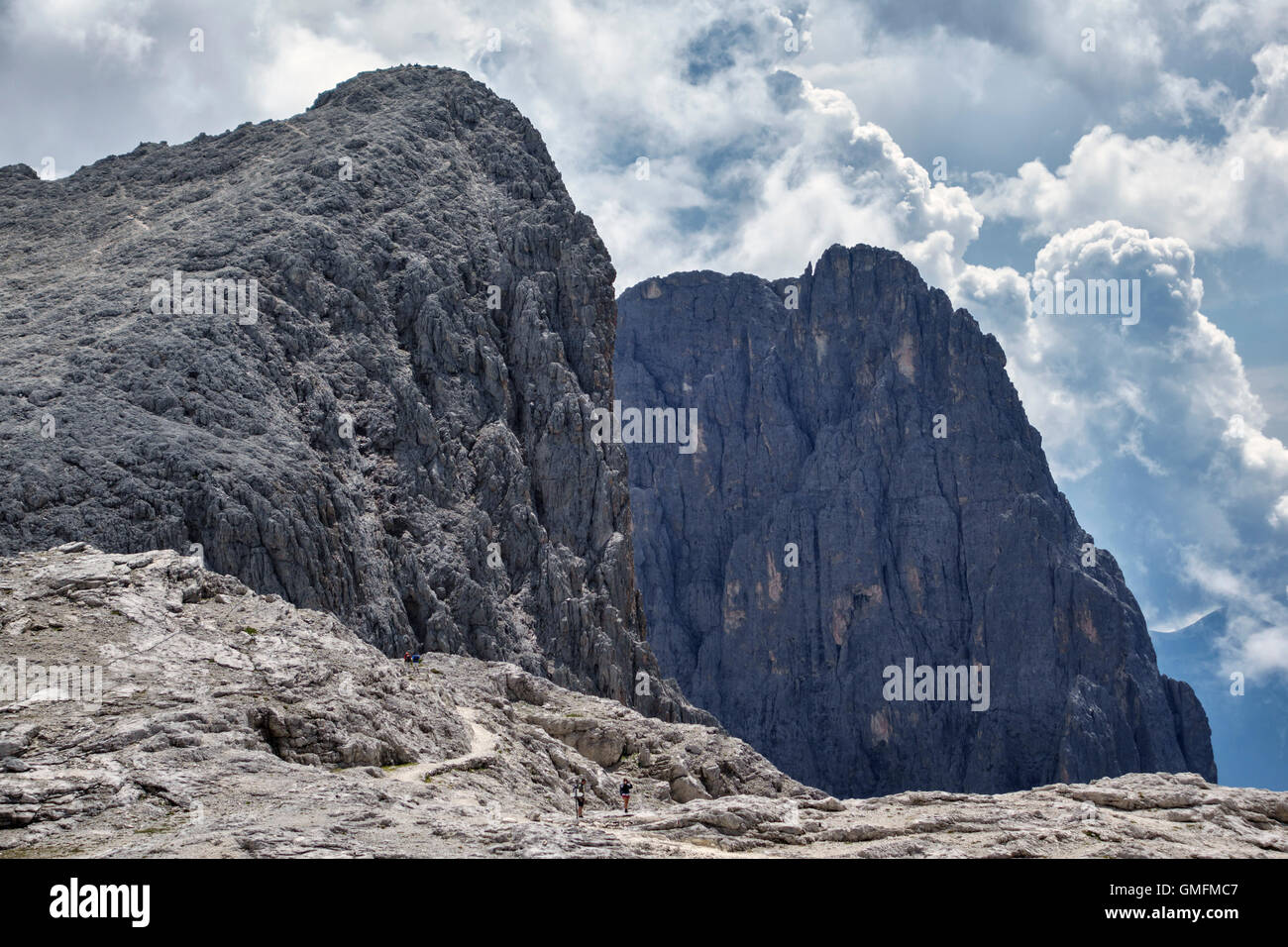 The Dolomites, Trentino, northern Italy. Walkers beneath the Croda di Roda (2694m) in the Pale di San Martino in summer Stock Photo