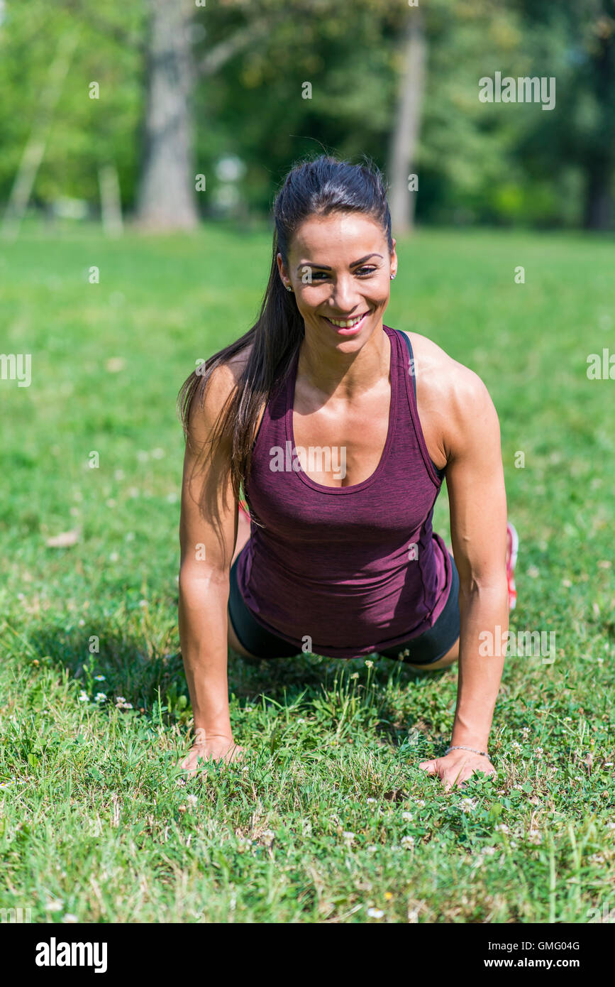 Young woman taking exercises in a park Stock Photo - Alamy