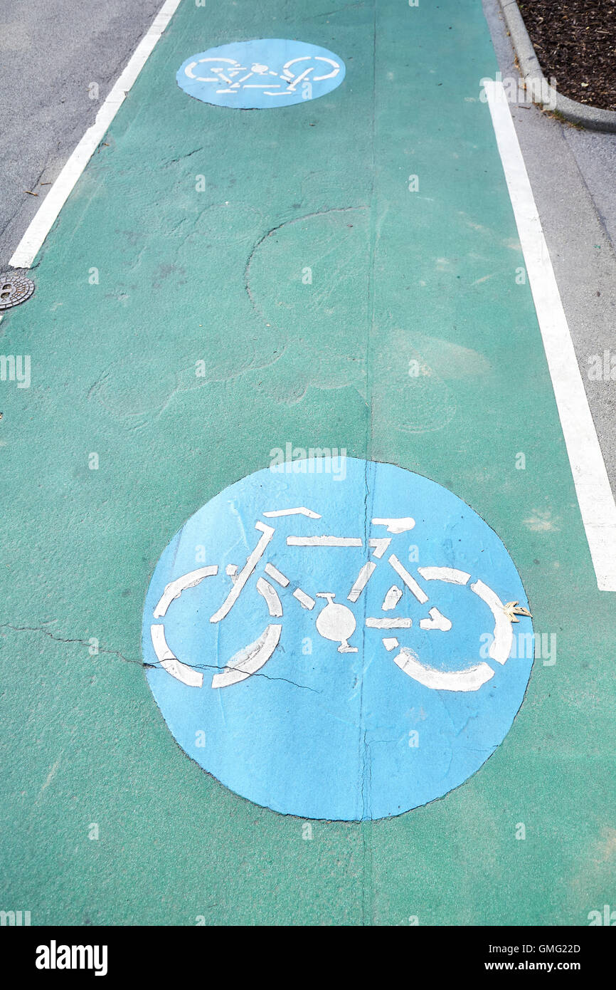 Bicycle path signs on a green painted road. Stock Photo
