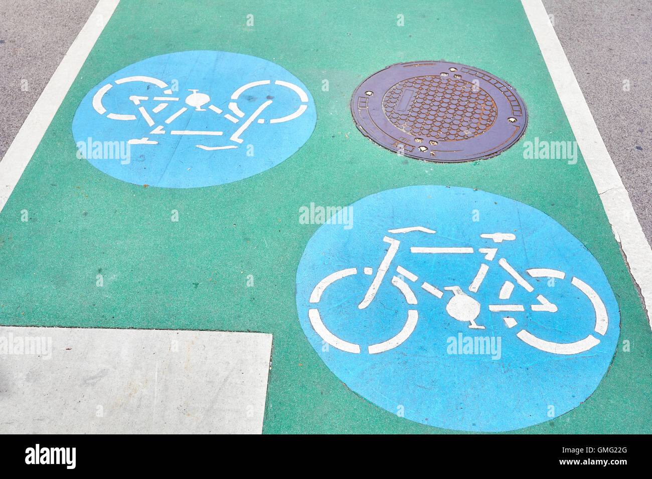 Bicycle path signs on a green painted road. Stock Photo