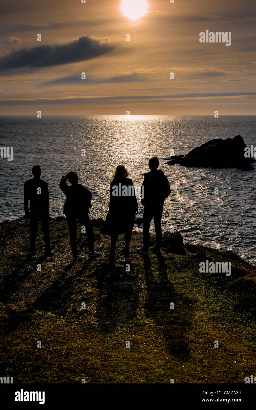 Four friends enjoy a spectacular summer evening on East Pentire Headland in Newquay, Cornwall. Stock Photo