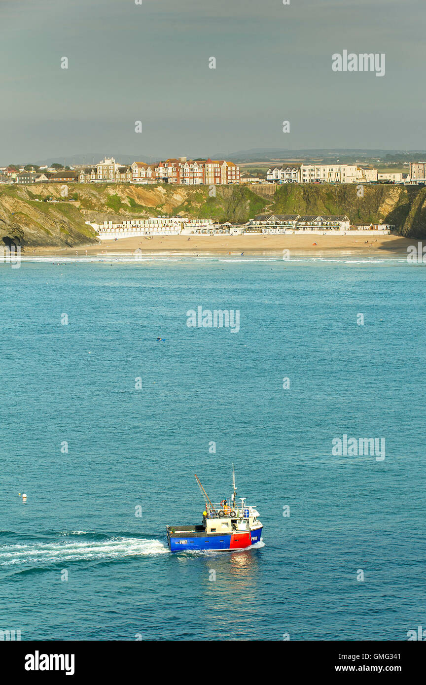 A fishing boat steams past Lusty Glaze Beach in Newquay, Cornwall. Stock Photo