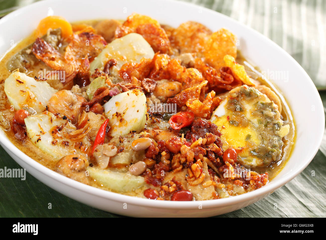 Lontong Sayur, an Indonesian specialty culinary dish consist of rice cake, bean curd, egg, peanut, and vegetable in spicy curry  Stock Photo