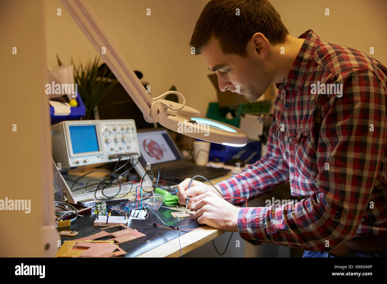 Electrical Engineer Soldering Circuit Board At Work Bench Stock Photo