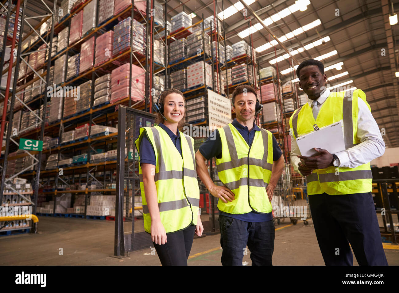 Distribution warehouse manager and colleagues look to camera Stock ...