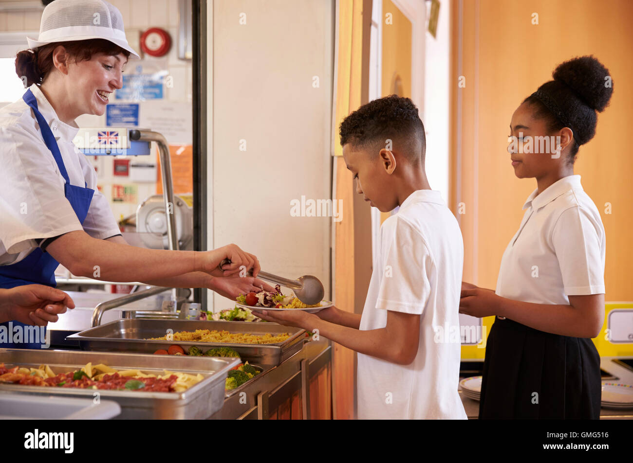 dinner-lady-serving-kids-in-a-school-cafeteria-hi-res-stock-photography