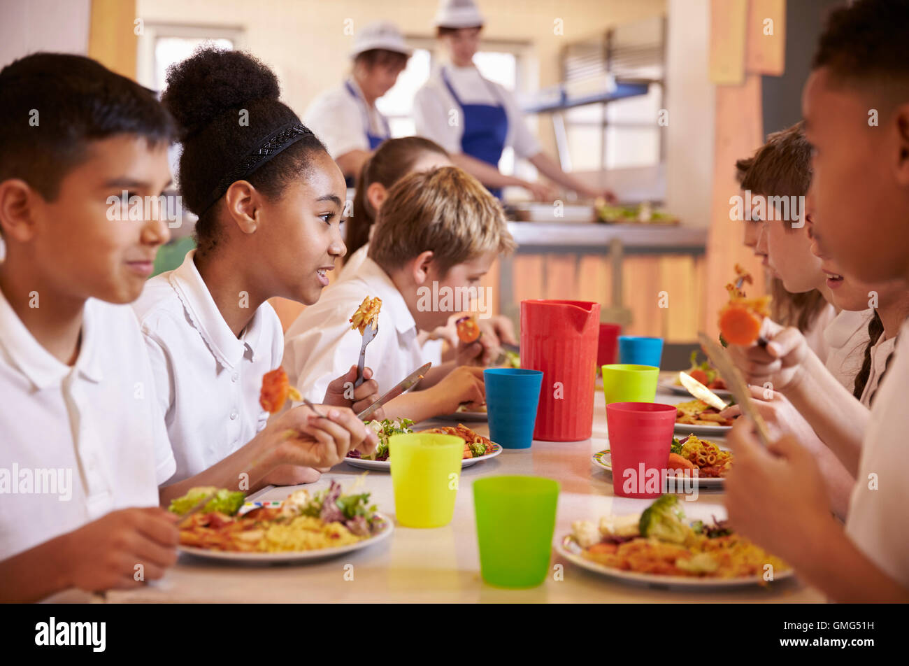 Primary school kids eat lunch in school cafeteria, close up Stock Photo
