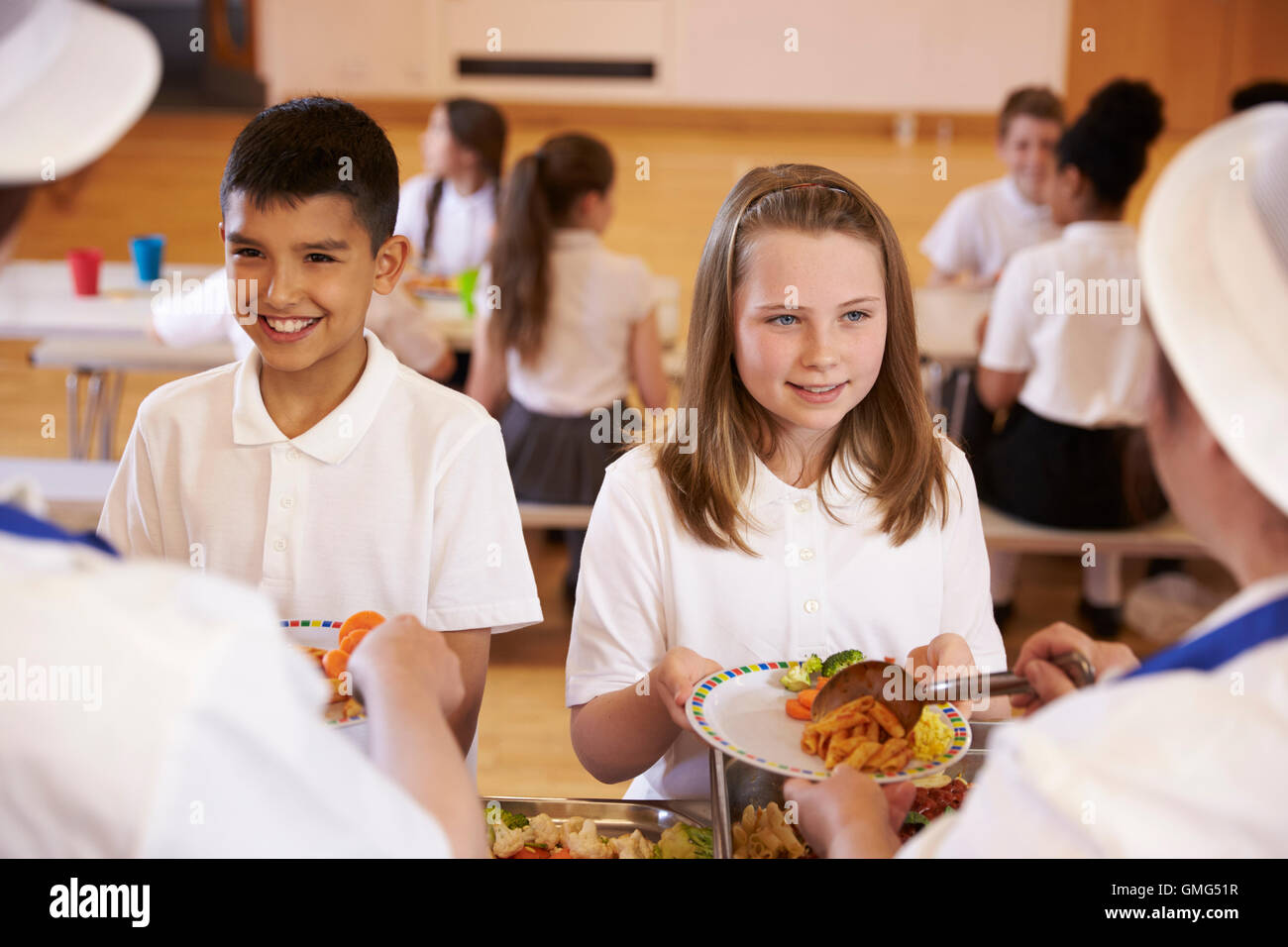 Children in village school canteen being served cooked meal Stock Photo -  Alamy