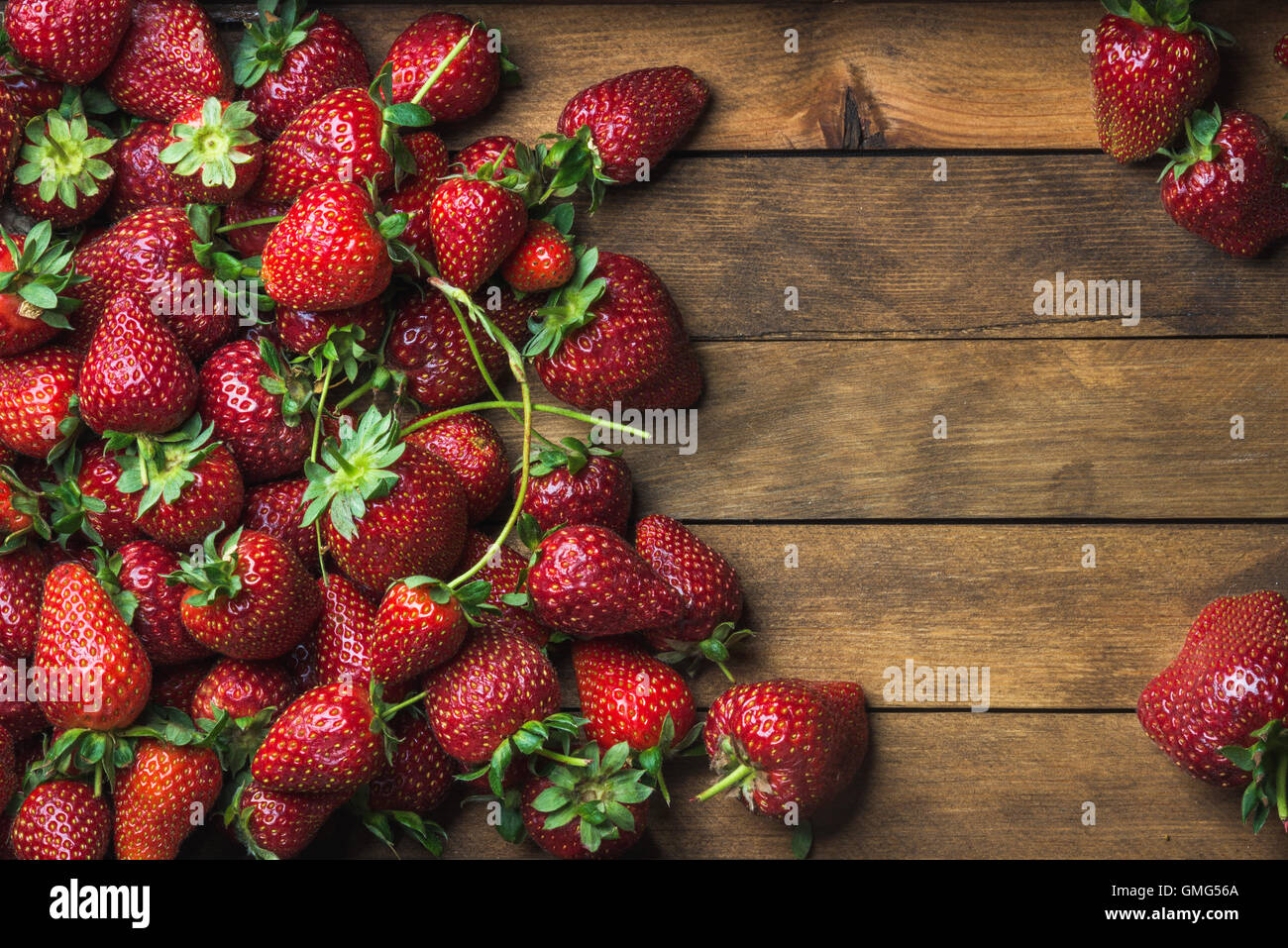 Strawberries over natural wooden background Stock Photo - Alamy