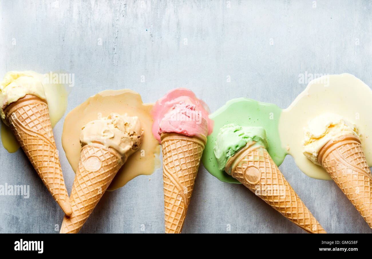 Colorful ice cream cones of different flavors. Melting scoops. Top view,  steel metal background Stock Photo