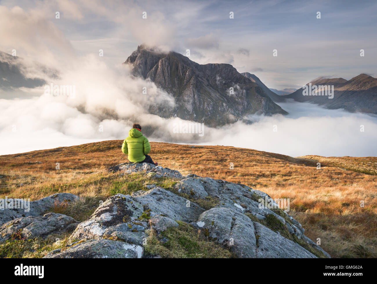 Walker above a temperature inversion on a mountain in the Scottish highlands, Scotland Stock Photo