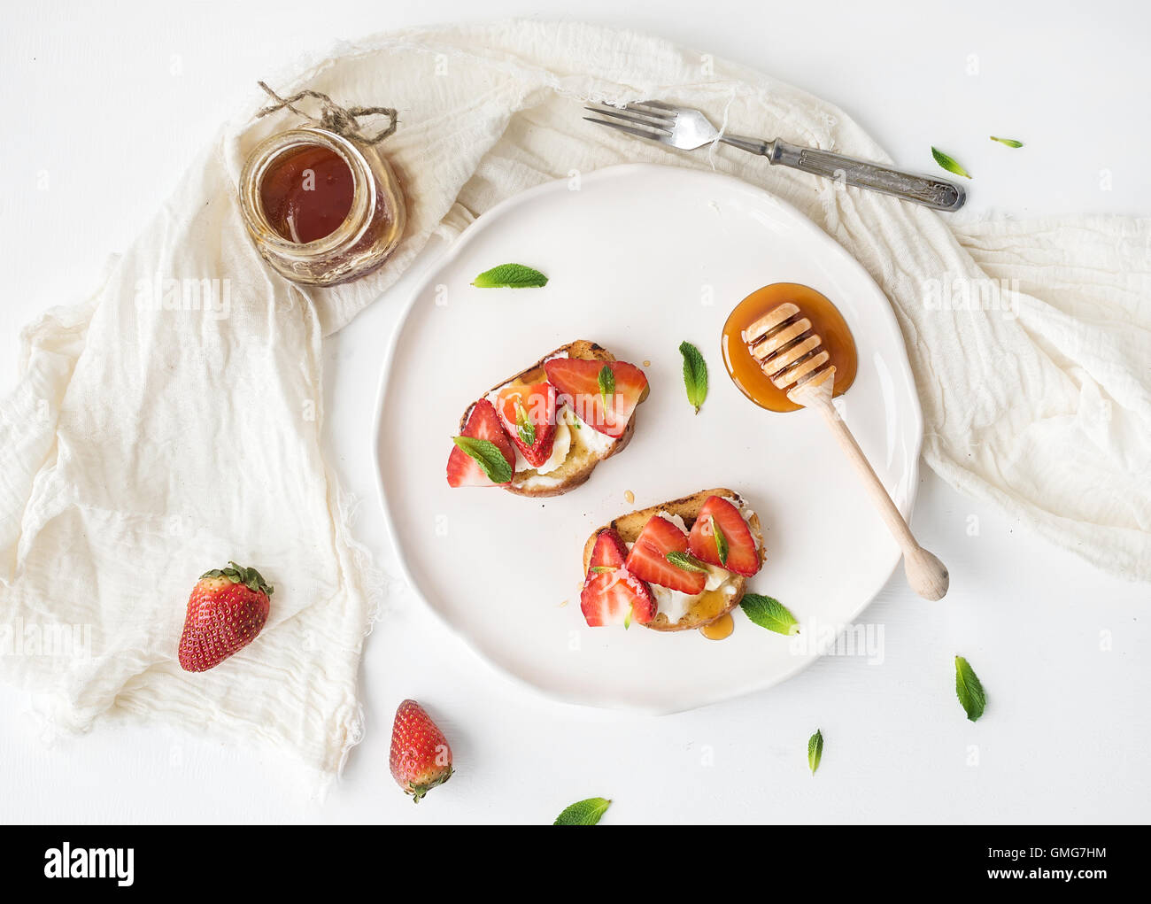 French toasts with strawberry, cream cheese, honey and mint on light ceramic plate Stock Photo