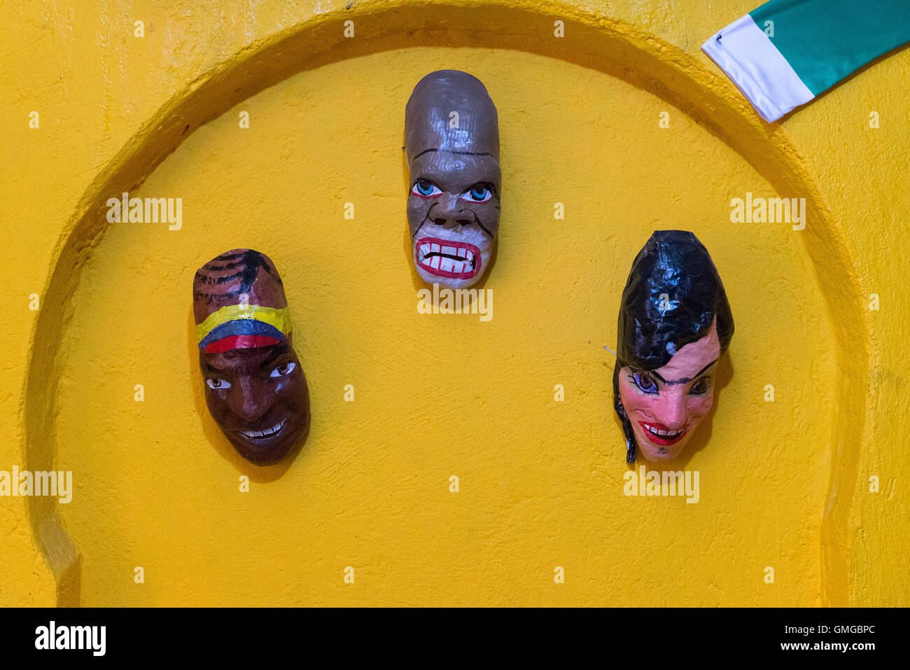 Colorful hand-made figure heads decorate wall in a small restaurant. Quito, Ecuador. Stock Photo