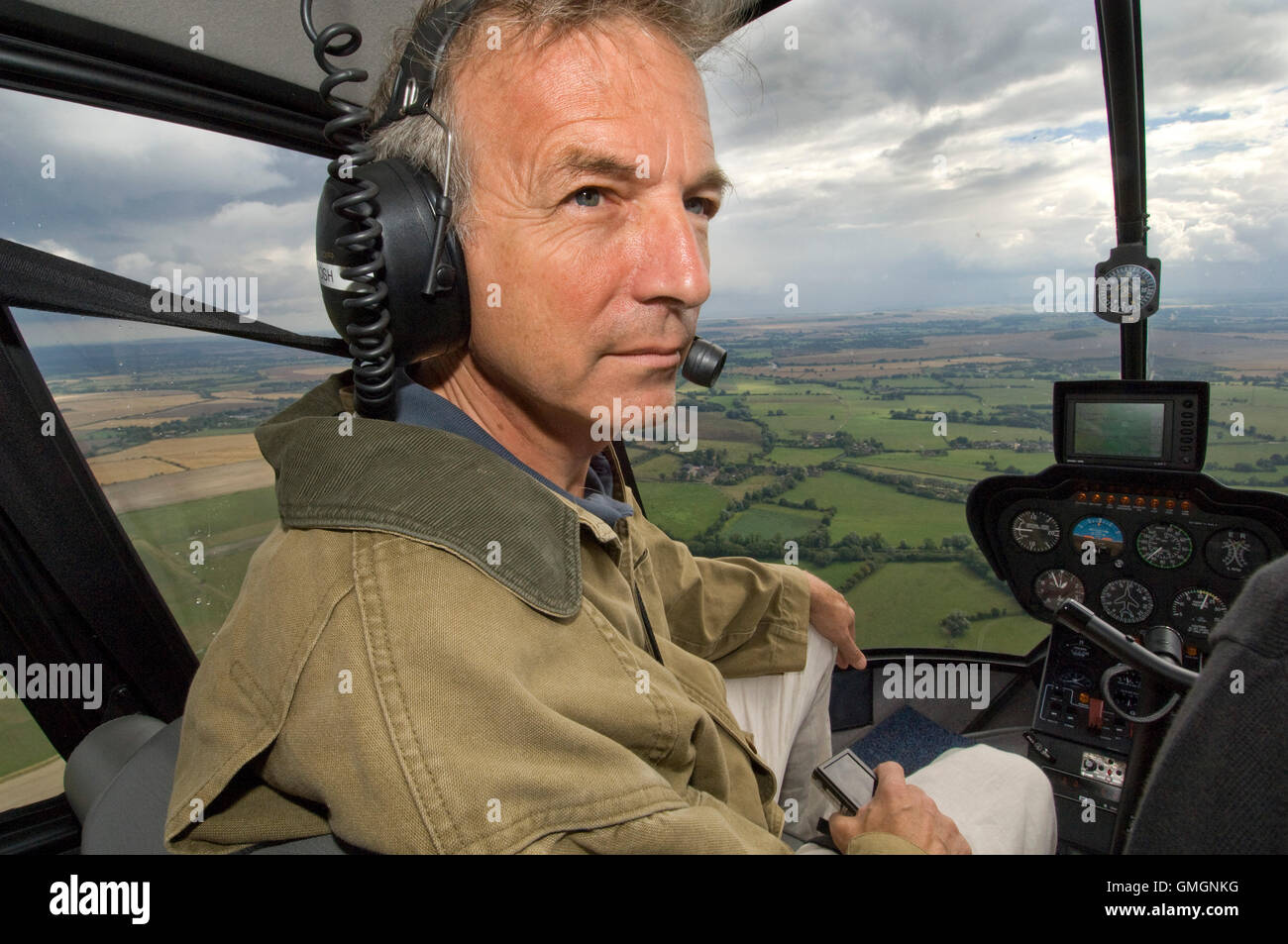 Crop circle investigator Clive Aslet ( Croppy/Croppies) searching for crop circles in Wiltshire ,UK,using a helicopter and looking at flat corn Stock Photo